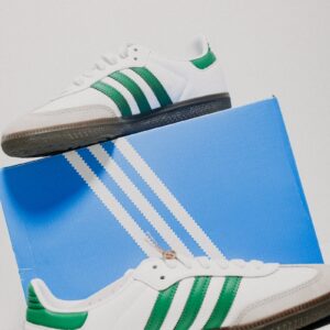 a pair of white and green adidas sneakers